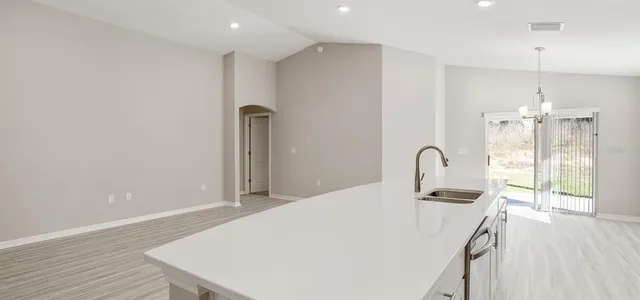 a kitchen with stainless steel appliances a refrigerator sink and wooden floor