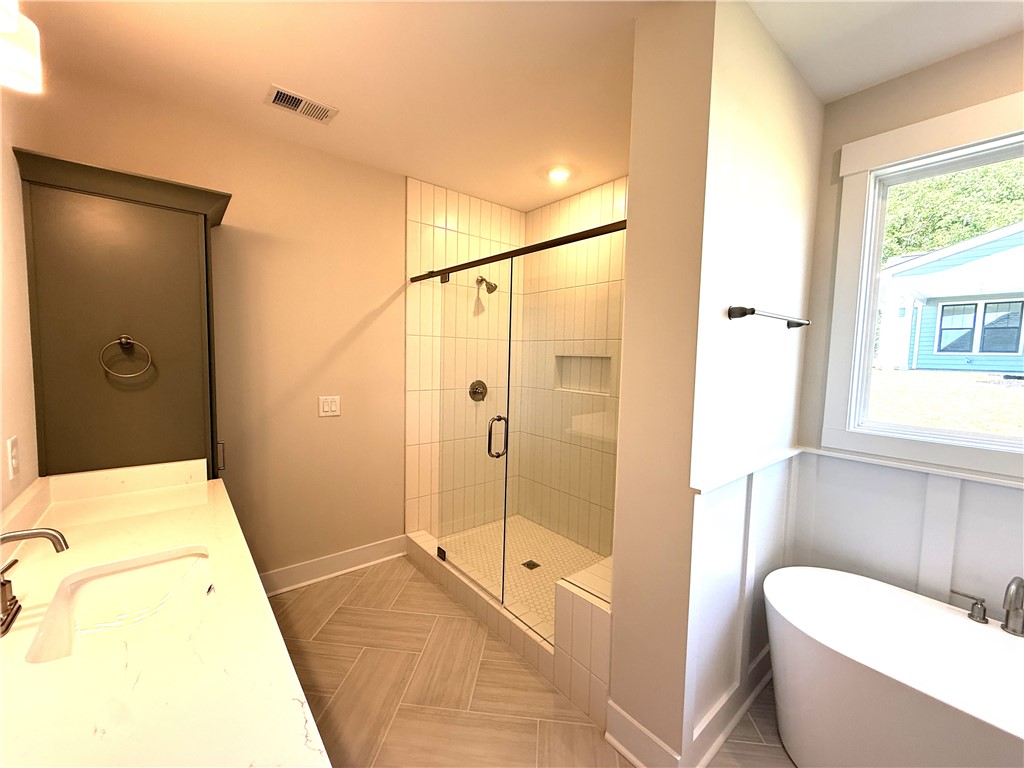 504 Tilman Court Anderson, SC 29621 - Photo 17 of 28 This spacious bathroom offers a serene retreat with a walk-in shower and a modern soaking tub.