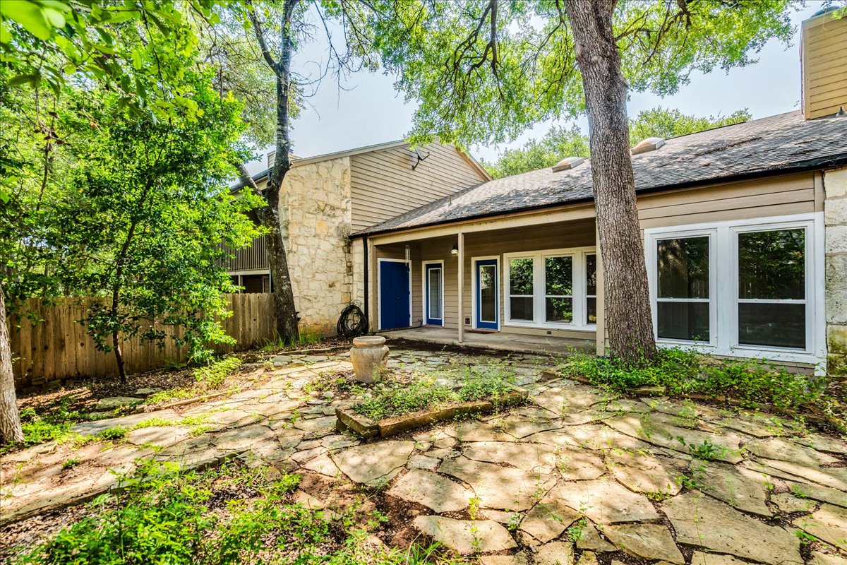 3809 Spicewood Springs Road, Unit 127 Austin, TX 78759 - Photo 25 of 29 Mature trees and flagstone path frame a welcoming covered patio space.