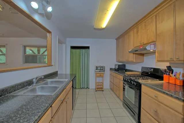 a kitchen with stainless steel appliances granite countertop a sink stove and cabinets