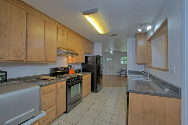 a kitchen with a sink a stove and cabinets