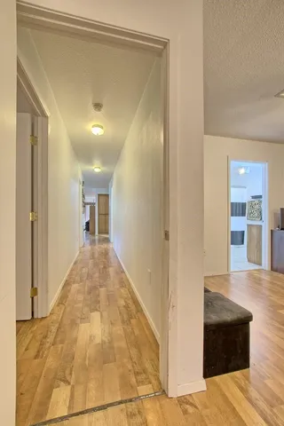 a view of a hallway to a bedroom and kitchen