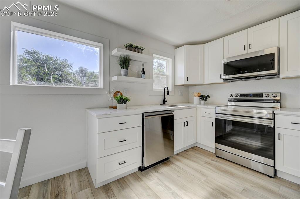 2459 East Willamette Avenue Colorado Springs, CO 80909 - Photo 7 of 19 a kitchen with cabinets stainless steel appliances and wooden floor