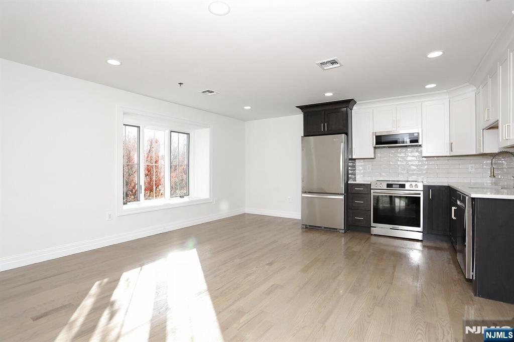 160 Terrace Street, Unit 2H Haworth, NJ 07641 - Photo 13 of 22 a kitchen with stainless steel appliances a microwave a stove a sink a refrigerator and a microwave