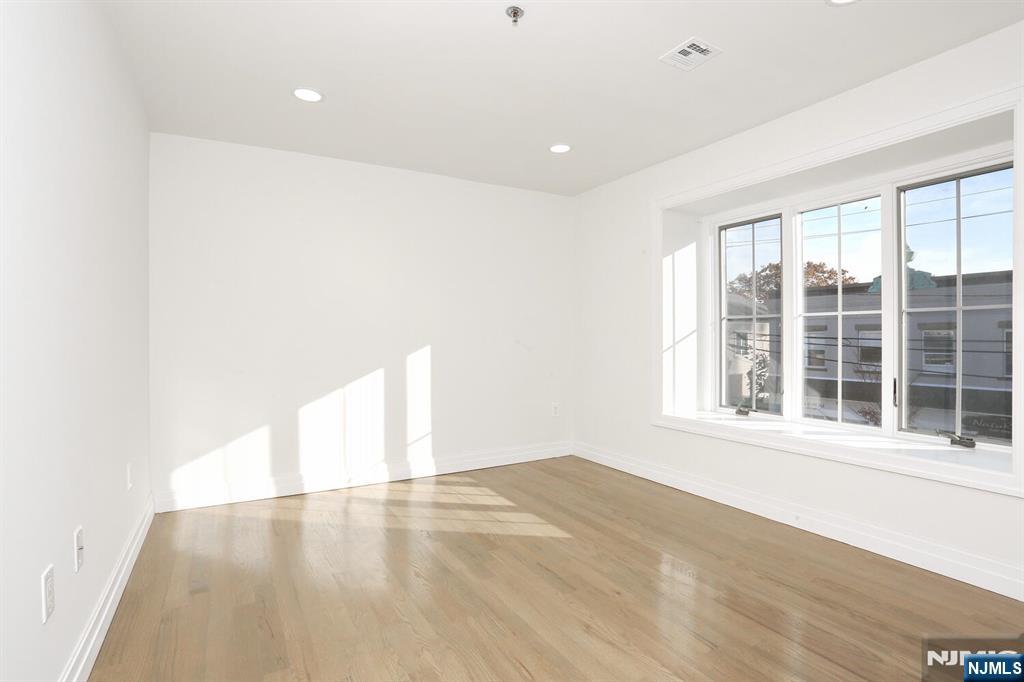 160 Terrace Street, Unit 2H Haworth, NJ 07641 - Photo 14 of 22 an empty room with wooden floor and windows