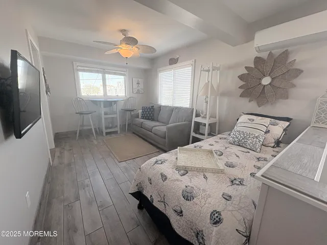 a bedroom with a bed and a flat tv screen on dresser
