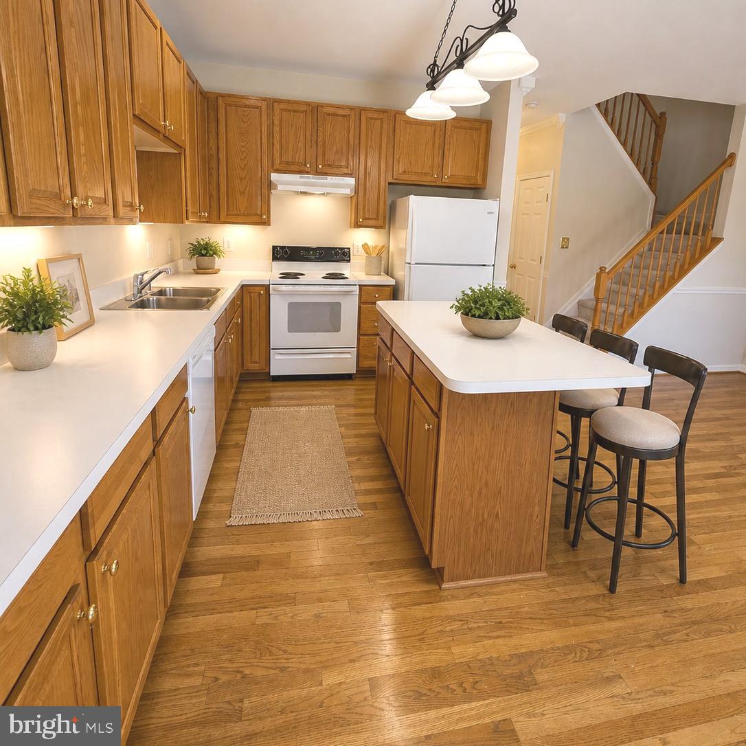 21674 Frame Square Broadlands, VA 20148 - Photo 8 of 43 a kitchen with granite countertop a stove a sink dishwasher and a refrigerator