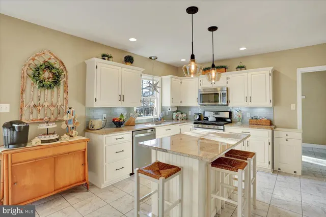 a kitchen with stainless steel appliances granite countertop a sink a stove and a wooden floors
