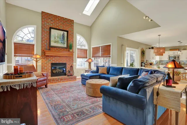 a living room with furniture a flat screen tv and kitchen view