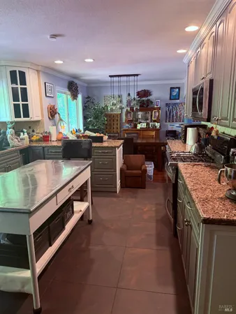 a kitchen with kitchen island granite countertop a stove and a sink