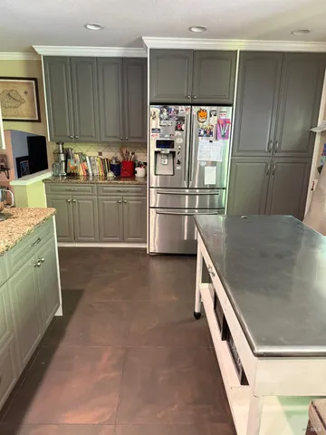 a kitchen with stainless steel appliances granite countertop a refrigerator and a sink