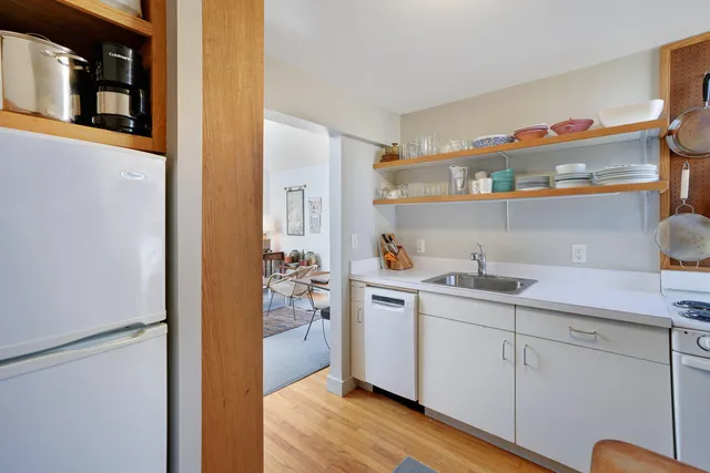a kitchen that has a sink a table and chairs in it