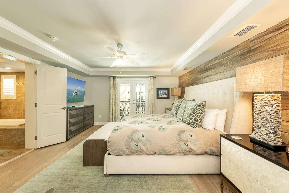 139 Simonton Street Key West, FL 33040 - Photo 31 of 68 a bedroom with a large bed and a flat tv screen on dresser