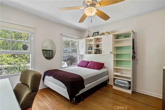 a bedroom with a bed a chandelier and a large window