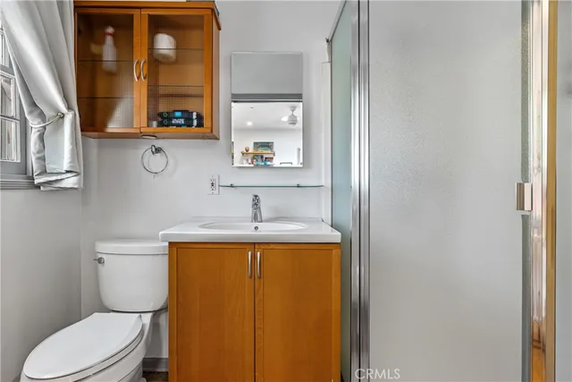 a bathroom with a granite countertop toilet sink and mirror