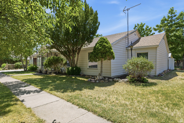 365 North Main Street Fillmore, UT 84631 - Photo 39 of 51 White siding exterior with a light-colored shingle roof, mature trees, established shrubs, and a concrete walkway