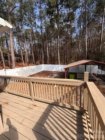 a view of deck with chairs and wooden fence