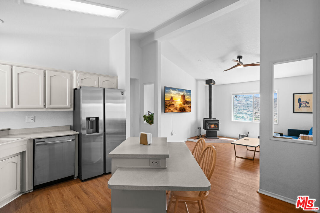 1794 Rebel Road Acton, CA 93551 - Photo 11 of 36 a kitchen with stainless steel appliances a sink a stove a refrigerator cabinets and dining table