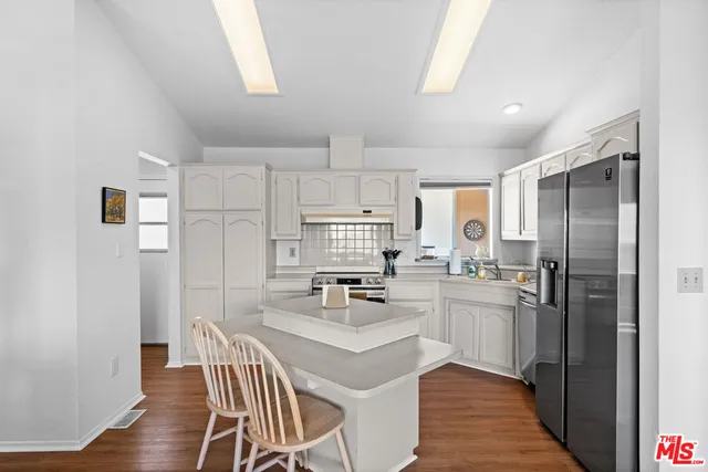a kitchen with refrigerator cabinets dining table and chairs