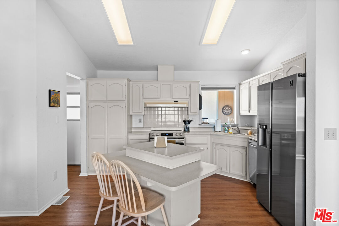 1794 Rebel Road Acton, CA 93551 - Photo 9 of 36 a kitchen with refrigerator cabinets dining table and chairs