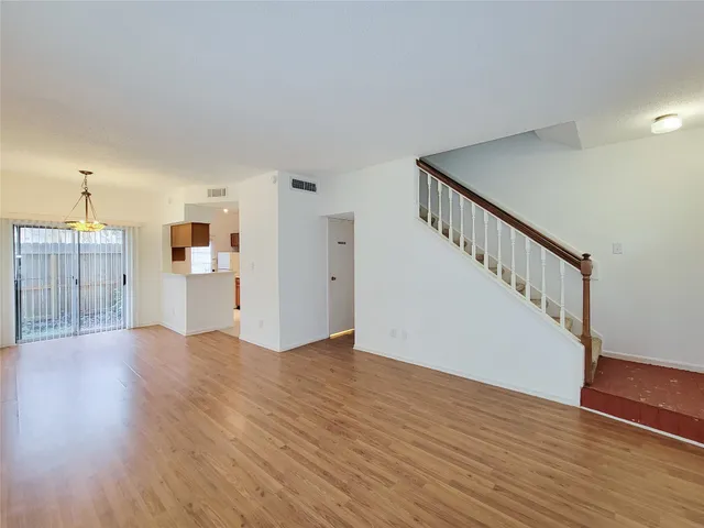 a view of a kitchen with wooden floor and stairs