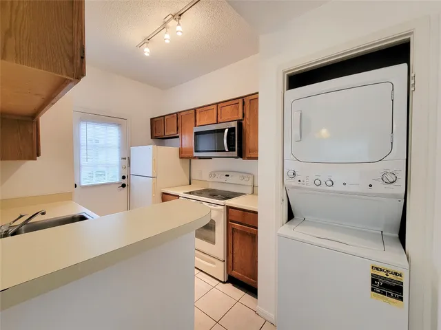 a kitchen with a sink and a stove top oven with wooden floor