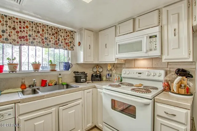a kitchen with white cabinets and white appliances
