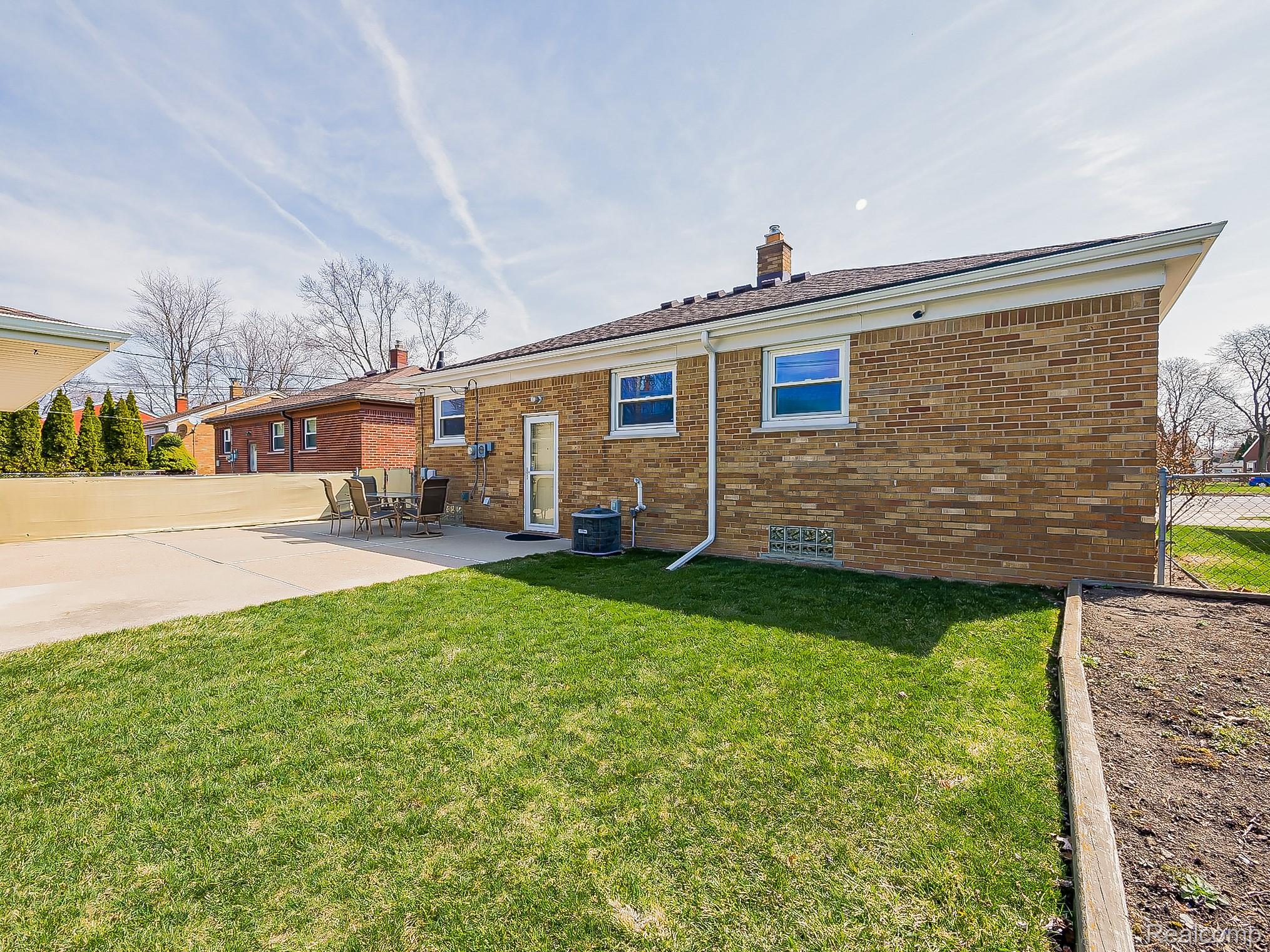 8634 Allen Road Allen Park, MI 48101 - Photo 31 of 38 Rear view of house featuring brick siding, a chimney, and a patio