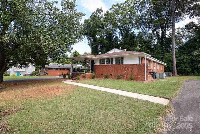 a front view of a house with a garden and trees