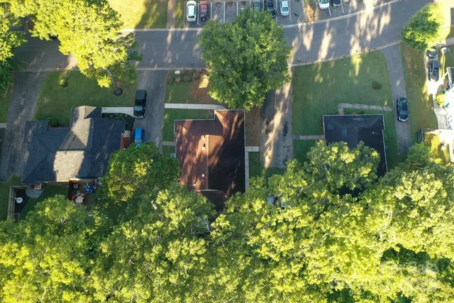 an aerial view of a house with a yard and large trees