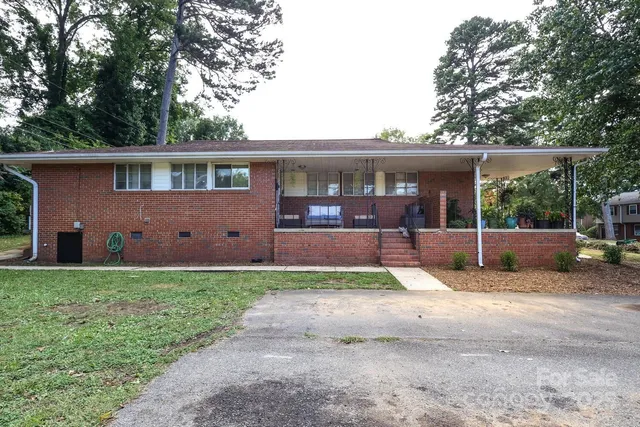 a view of house with backyard and a tree