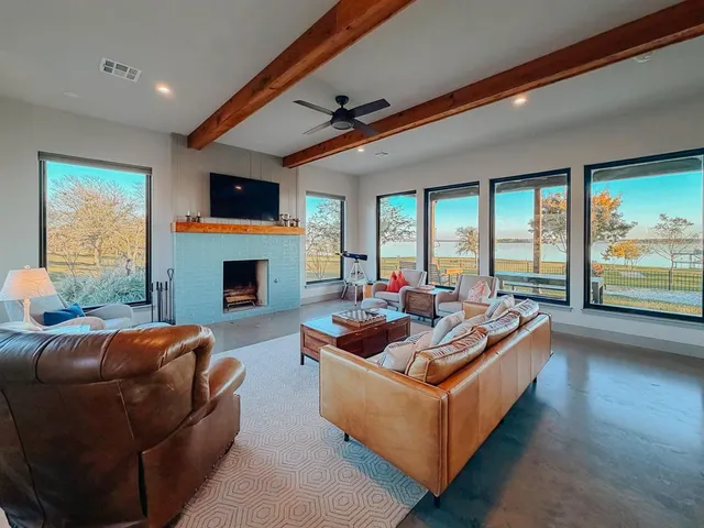 a living room with furniture a fireplace and a large window