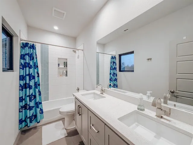 a bathroom with a double vanity sink a large mirror and shower