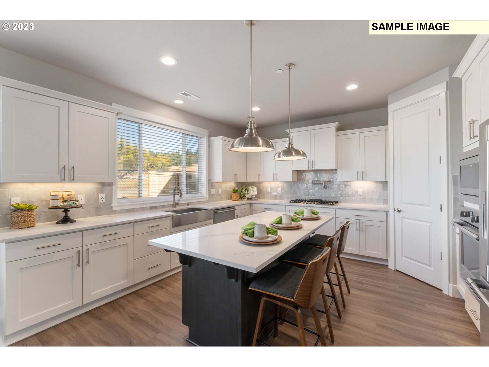 5597 North 94th Avenue, Unit LT246 Camas, WA 98607 - Photo 3 of 32 a kitchen with a dining table chairs wooden cabinets and wooden floor