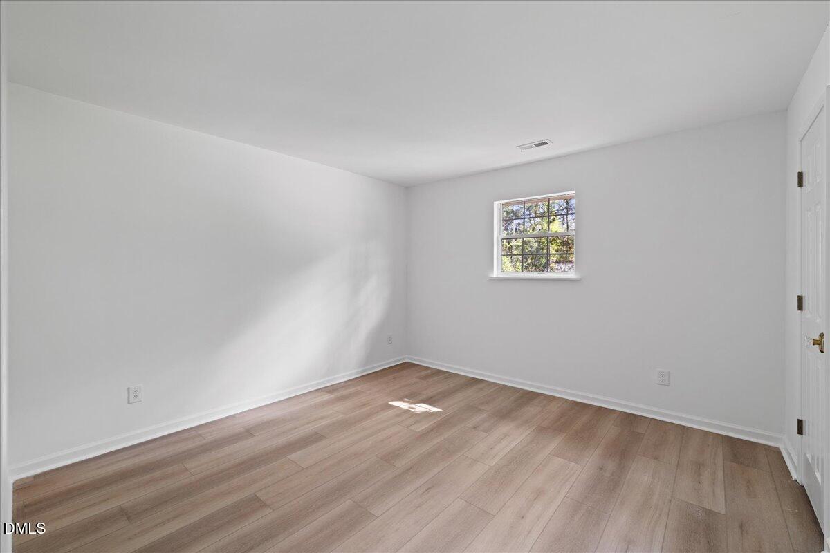 809 Felicia Street Durham, NC 27704 - Photo 18 of 31 an empty room with wooden floor and windows