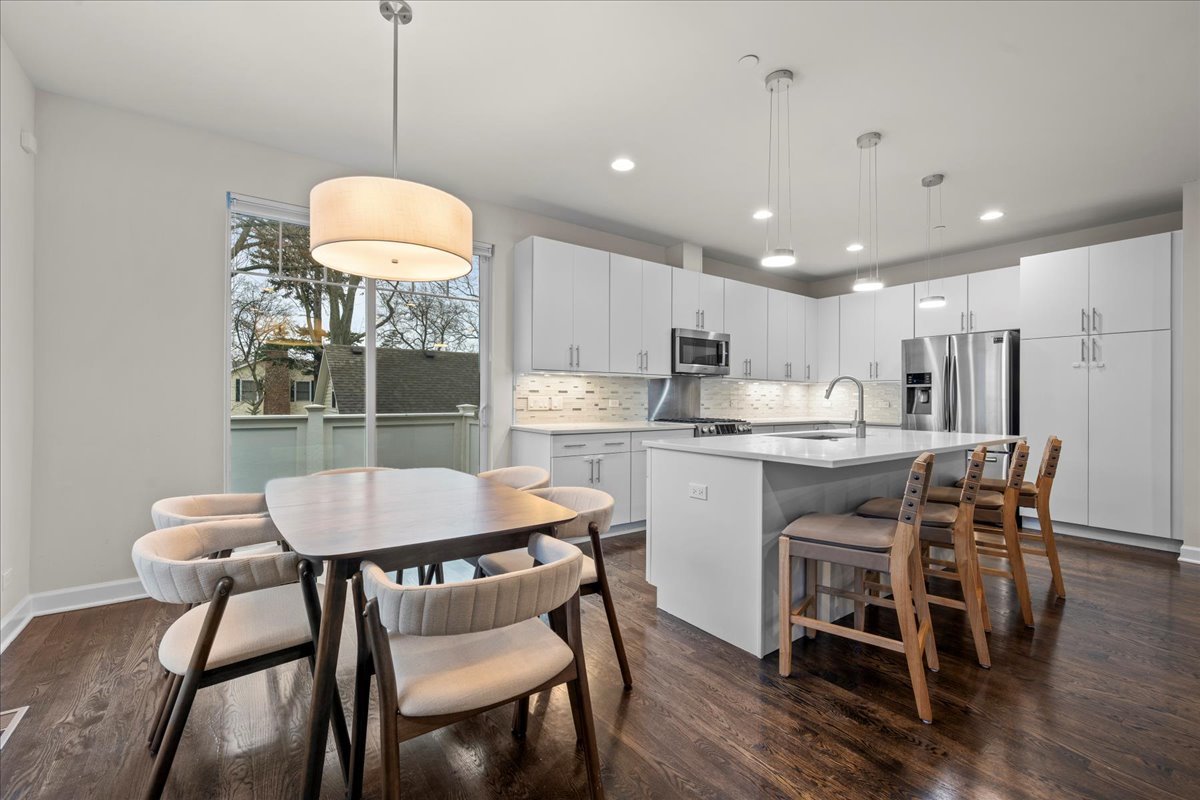 834 Chestnut Street Deerfield, IL 60015 - Photo 4 of 22 a kitchen with kitchen island a dining table and a refrigerator