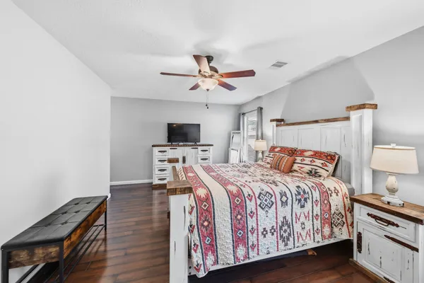 a bedroom with a bed and a flat tv screen on dresser