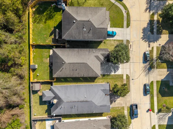 an aerial view of residential houses with outdoor space and swimming pool