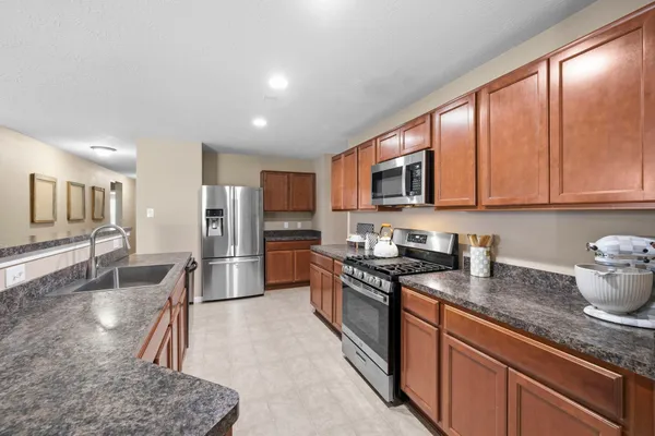 a kitchen with stainless steel appliances granite countertop a sink and a refrigerator