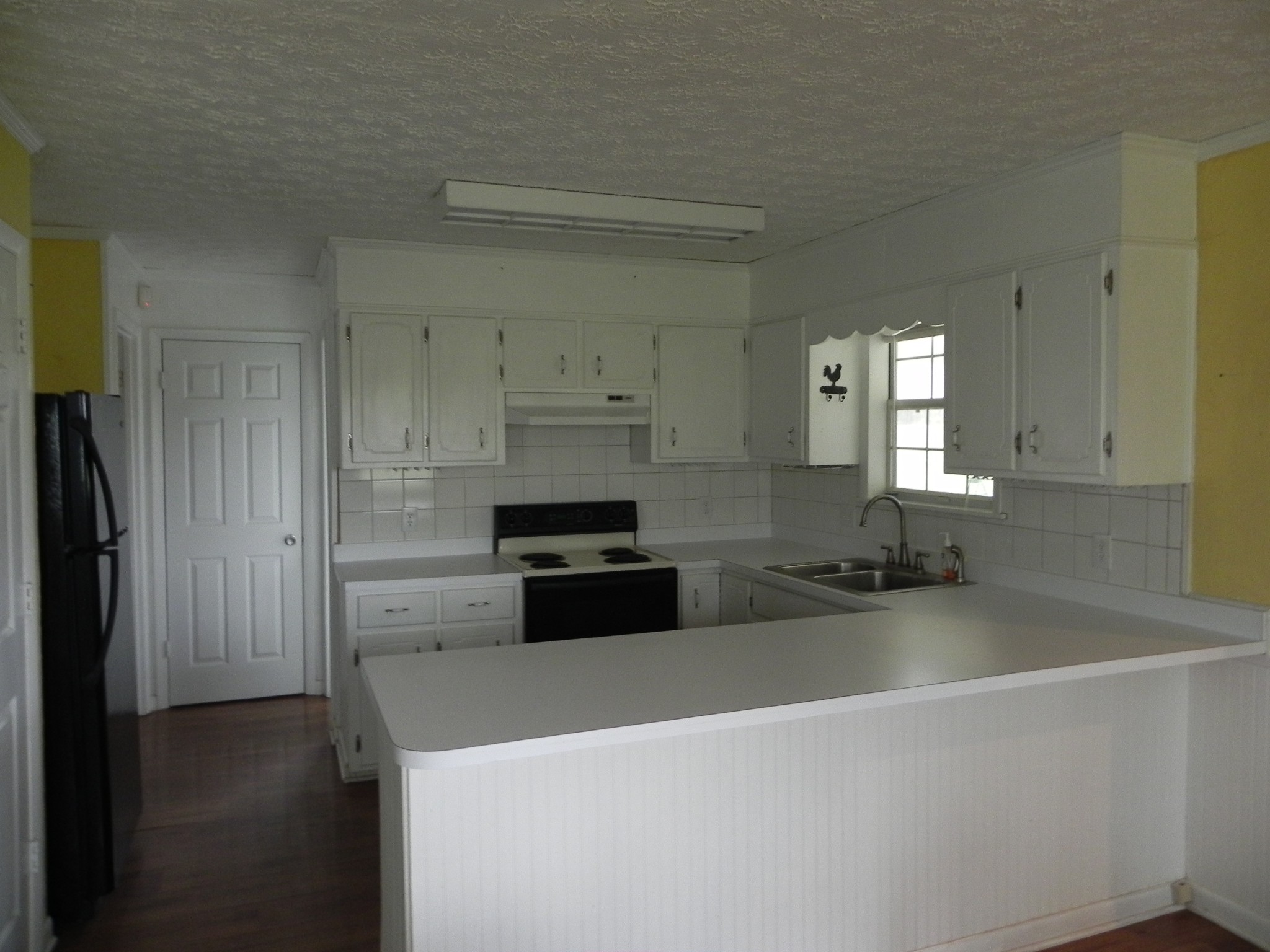 444 Nixon Road Red Boiling Springs, TN 37150 - Photo 9 of 41 a kitchen with stainless steel appliances a refrigerator a sink a stove and white cabinets
