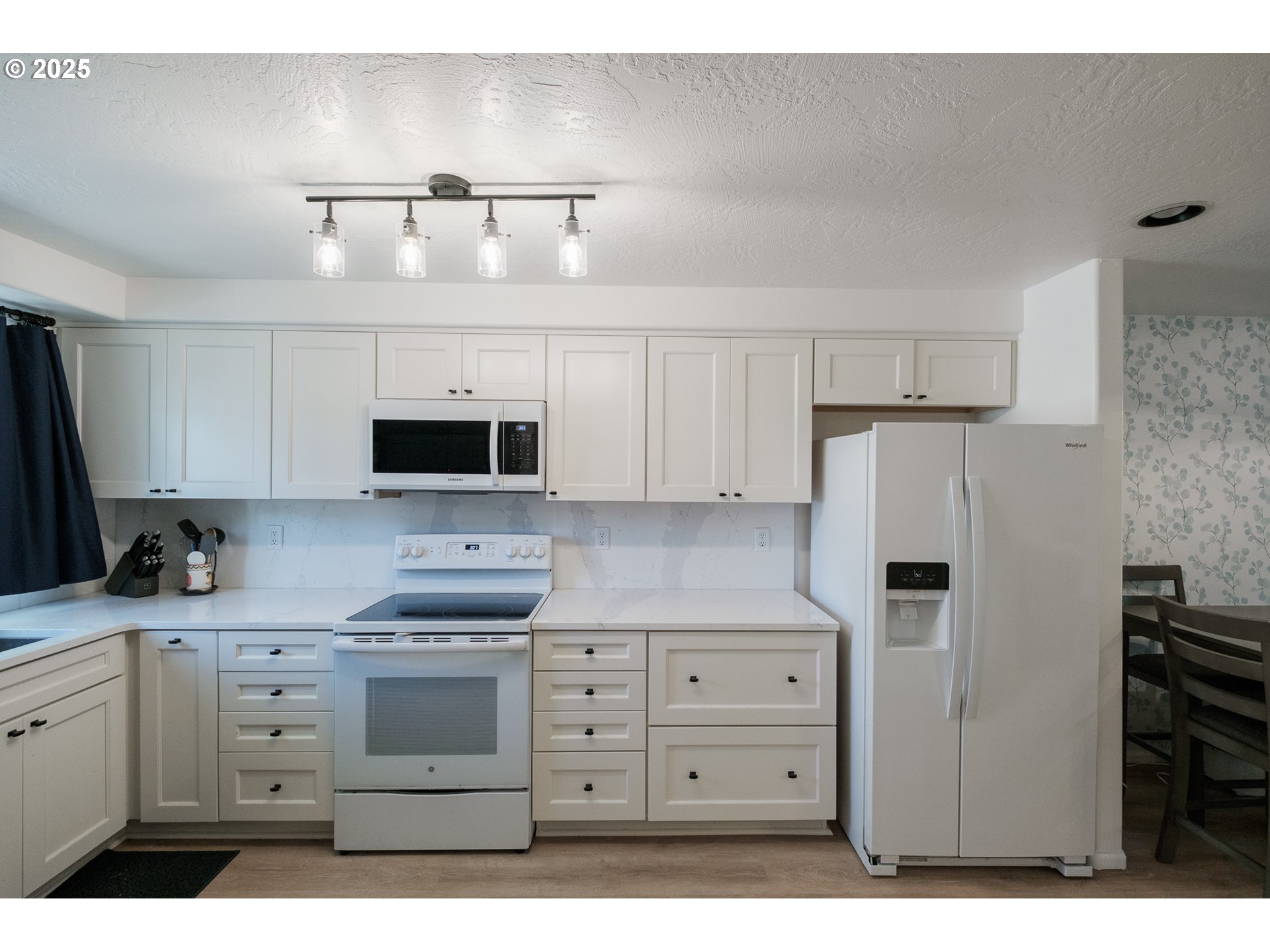 1548 Fetters Loop Eugene, OR 97402 - Photo 7 of 33 a kitchen with white cabinets and stainless steel appliances