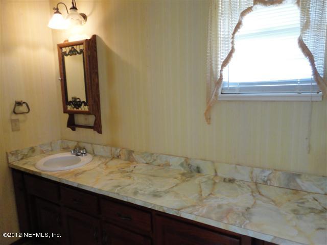 284 Barrataria Drive St. Augustine, FL 32080 - Photo 10 of 24 a bathroom with a granite countertop sink and a mirror