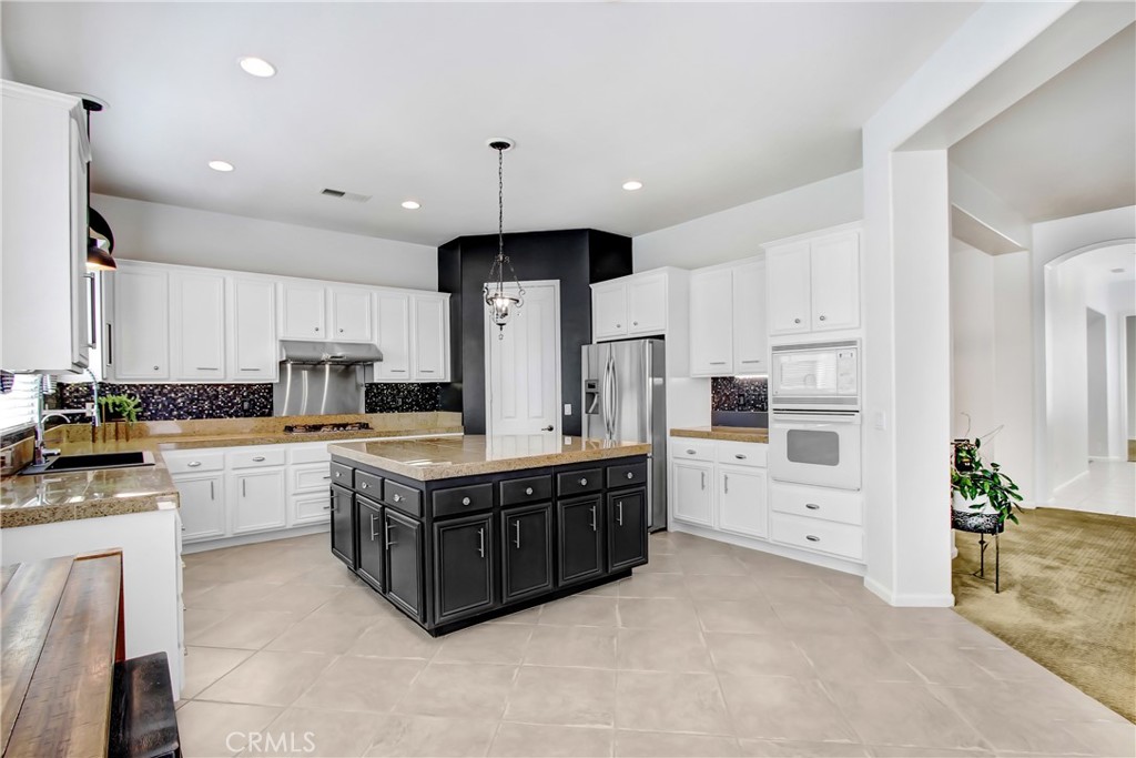 36109 Eagle Lane Beaumont, CA 92223 - Photo 14 of 42 a kitchen with stainless steel appliances a sink a stove a refrigerator and white cabinets