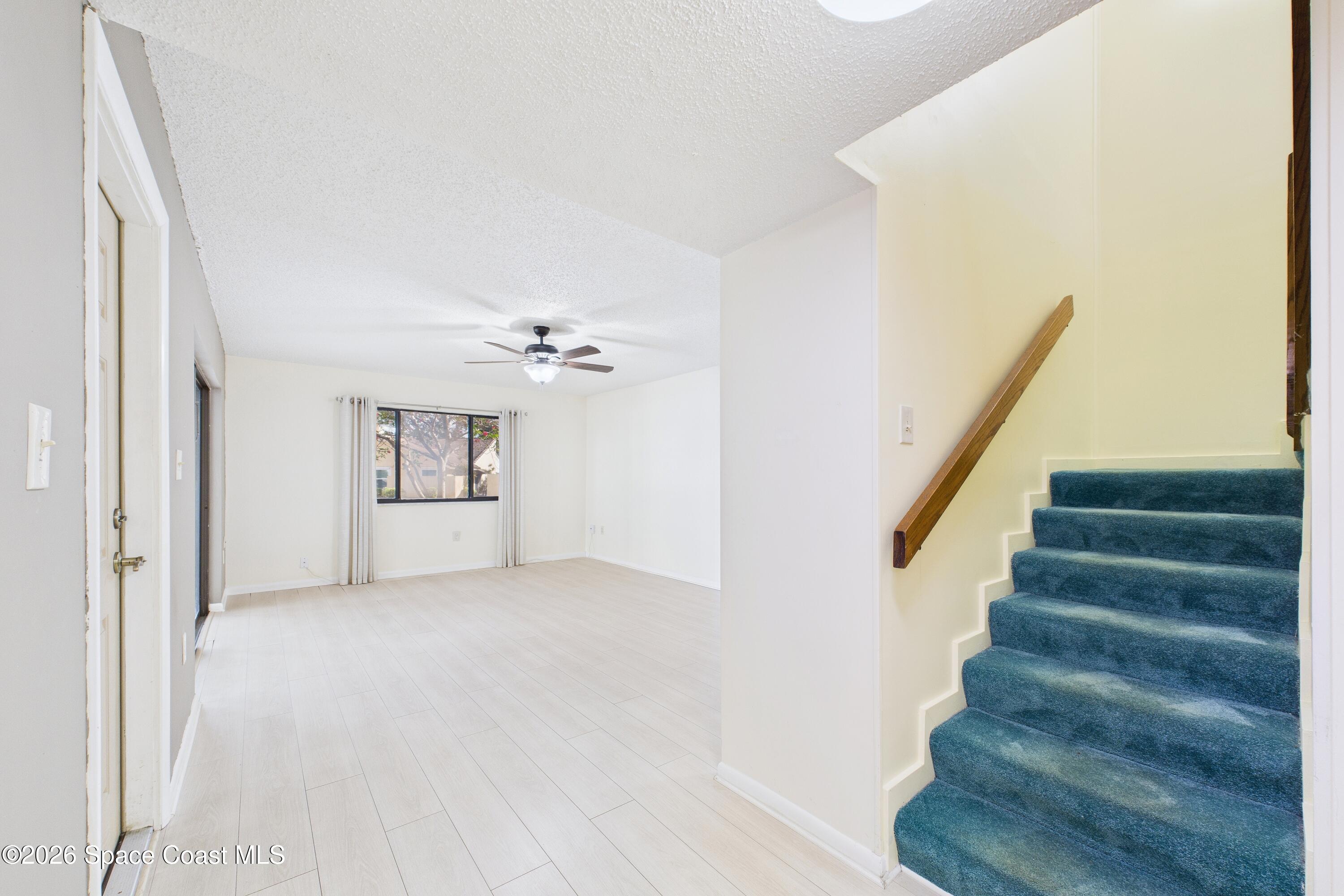 204 Country Club Drive Melbourne, FL 32940 - Photo 18 of 63 a view of an empty room with stairs and a chandelier