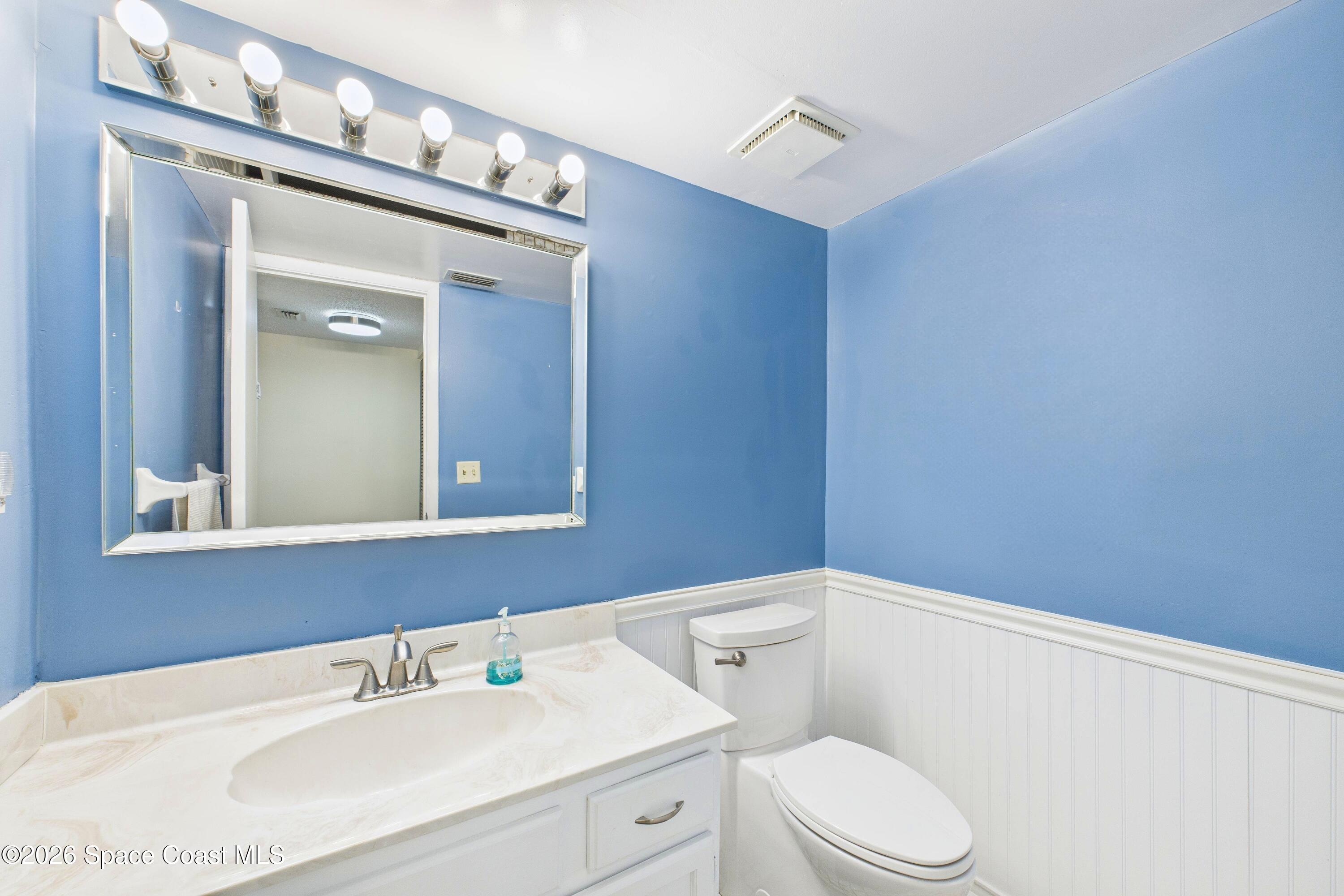 204 Country Club Drive Melbourne, FL 32940 - Photo 19 of 63 a bathroom with a sink a mirror and a toilet