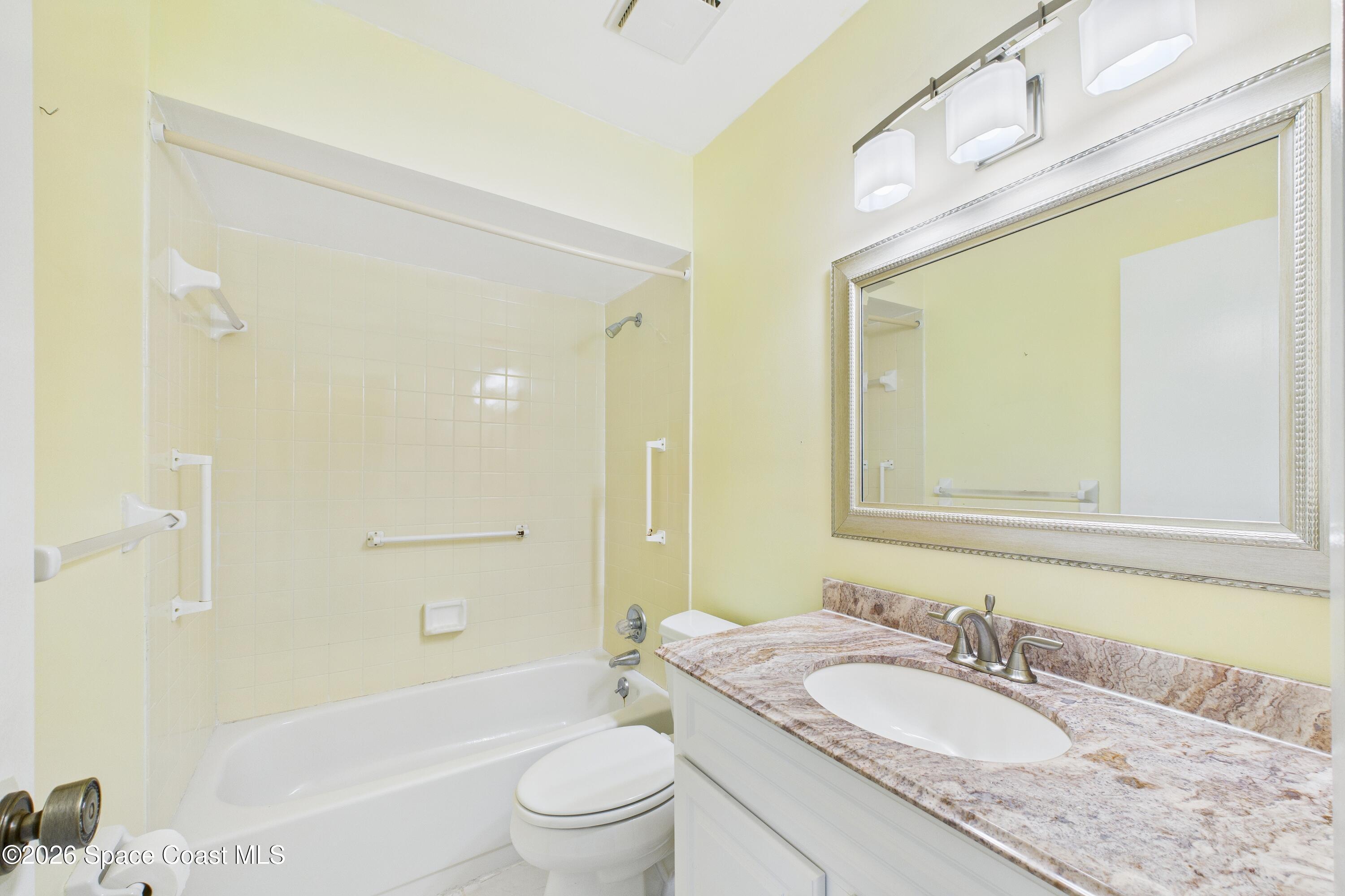 204 Country Club Drive Melbourne, FL 32940 - Photo 21 of 63 a bathroom with a granite countertop sink a toilet a mirror a bathtub and shower