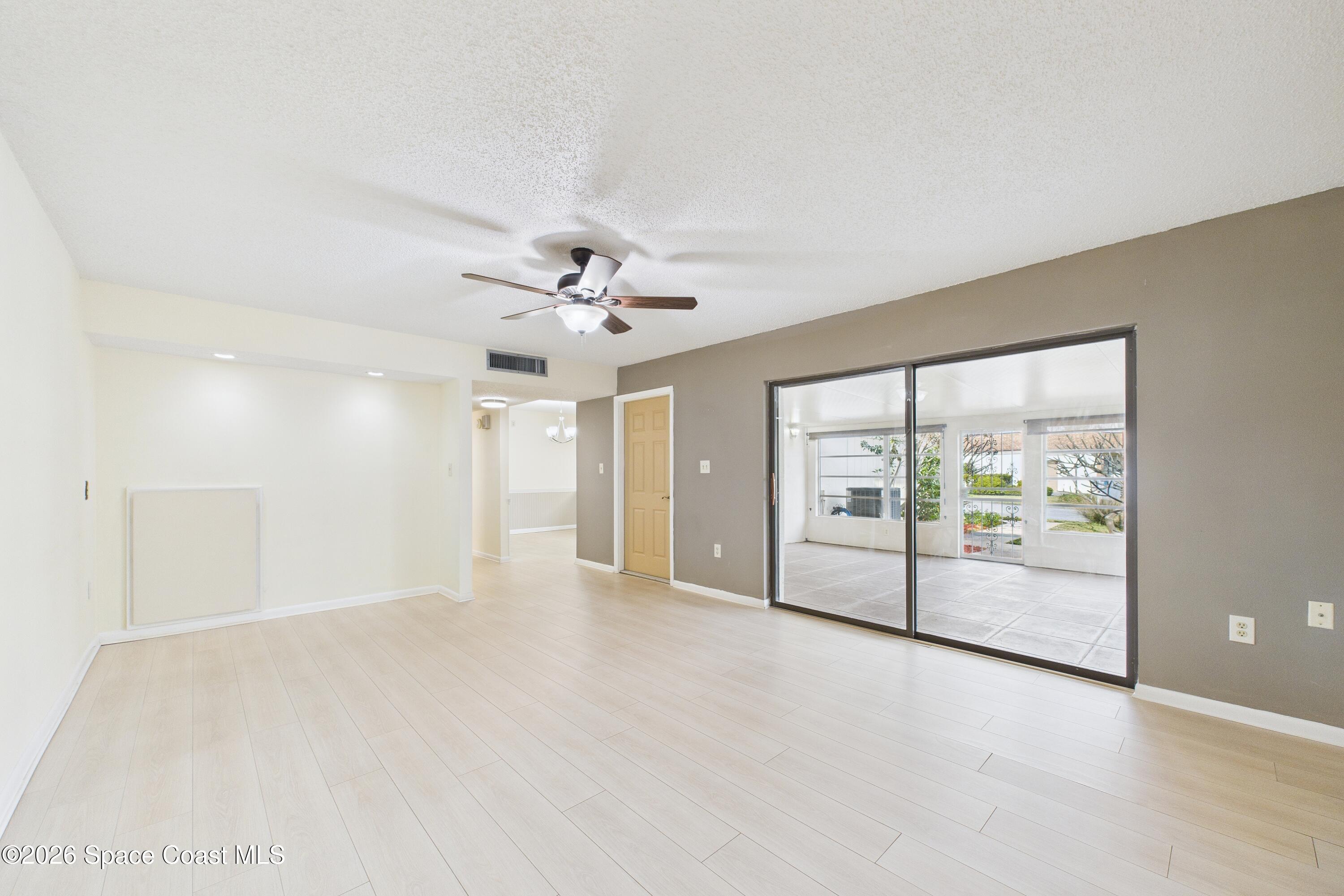 204 Country Club Drive Melbourne, FL 32940 - Photo 43 of 63 an empty room with chandelier fan and windows