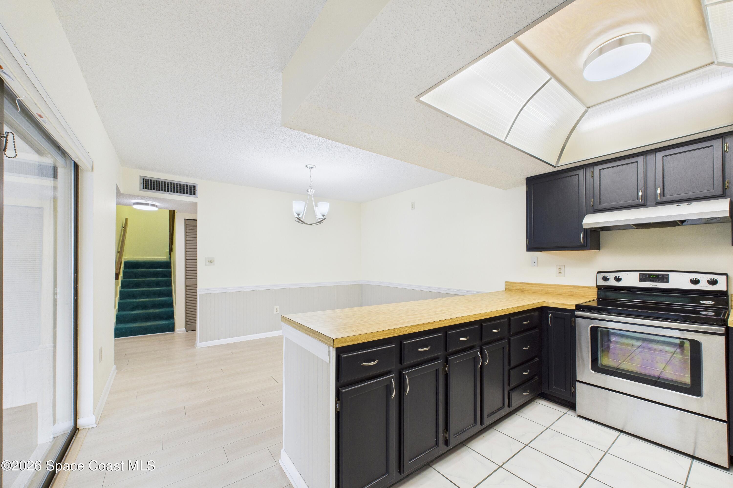 204 Country Club Drive Melbourne, FL 32940 - Photo 52 of 63 a kitchen with stainless steel appliances granite countertop a stove a sink and a refrigerator