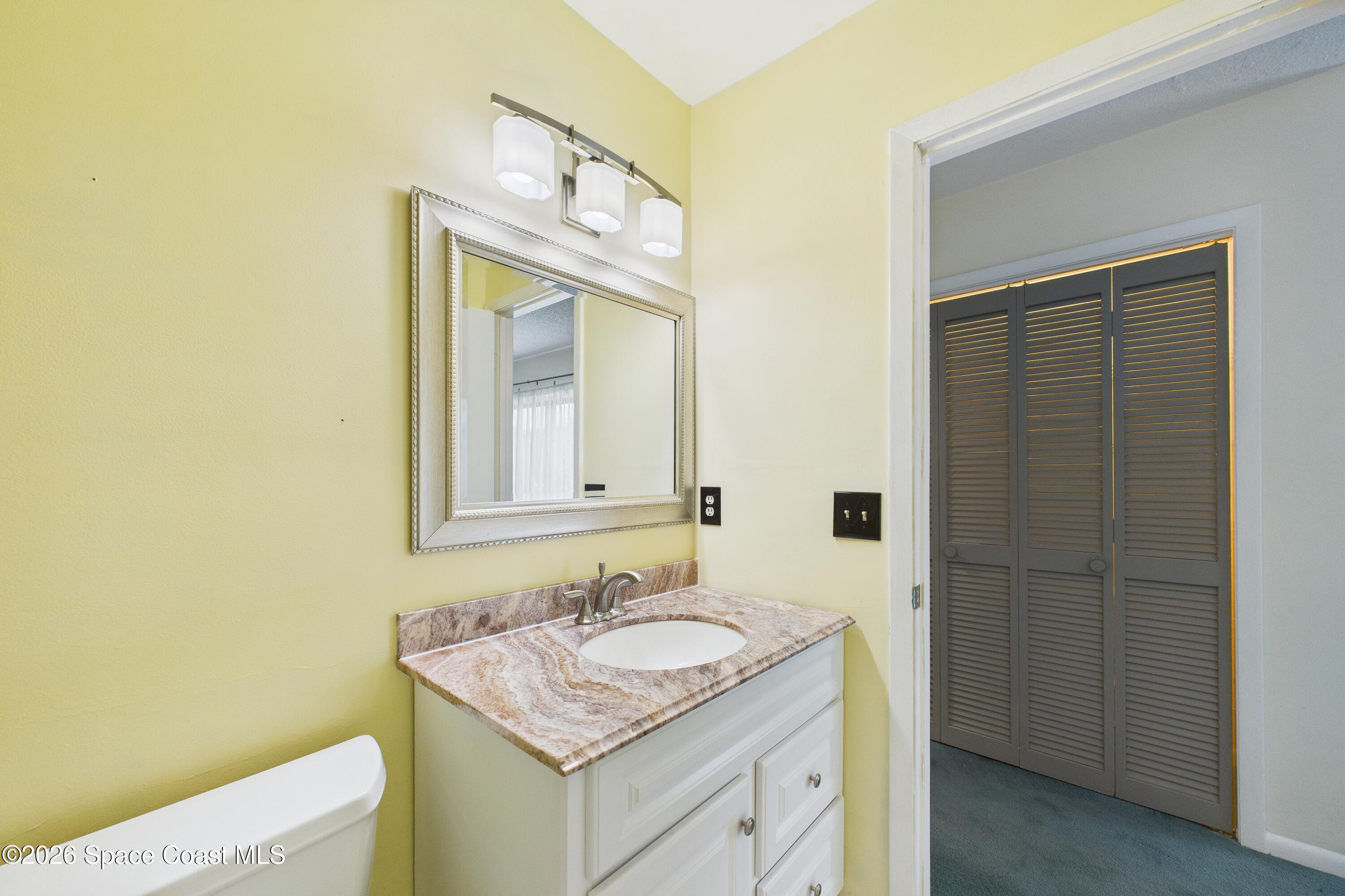 204 Country Club Drive Melbourne, FL 32940 - Photo 53 of 63 a bathroom with a granite countertop sink and a mirror