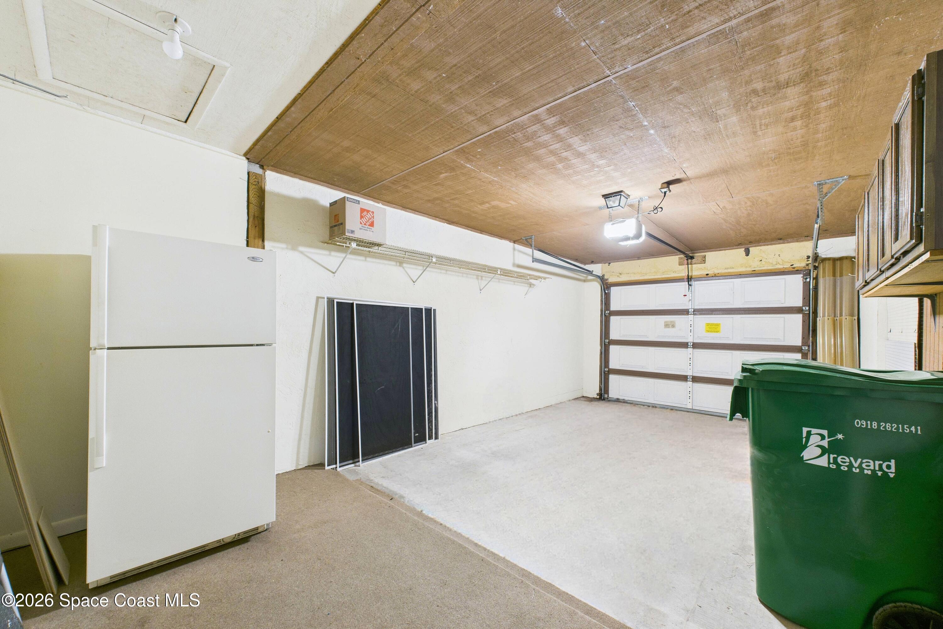 204 Country Club Drive Melbourne, FL 32940 - Photo 61 of 63 a view of hallway with a cabinets and a refrigerator